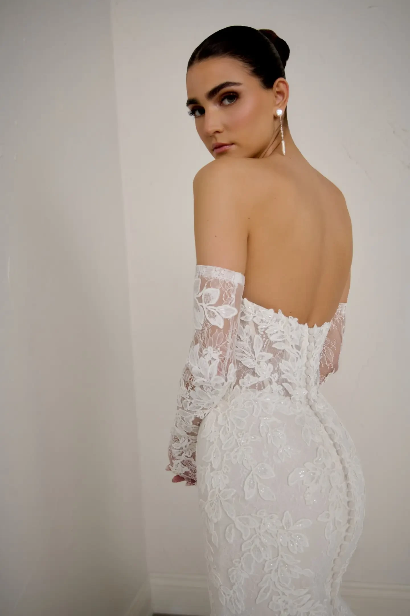 model is wearing a strapless wedding dress with gloves