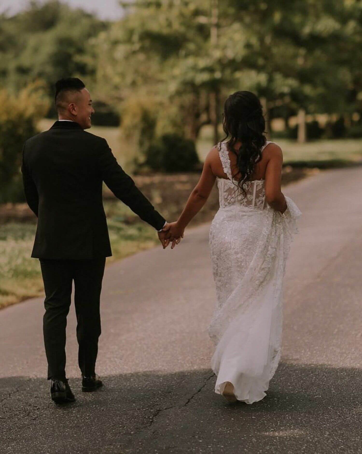 Сouple wearing a white gown and a black suit. Mobile image