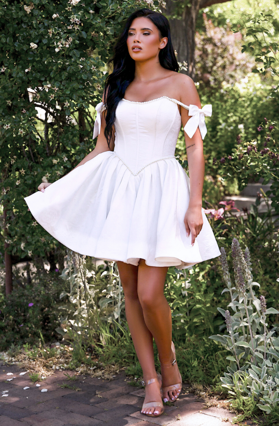model is wearing an off the shoulder a-line mini wedding dress
