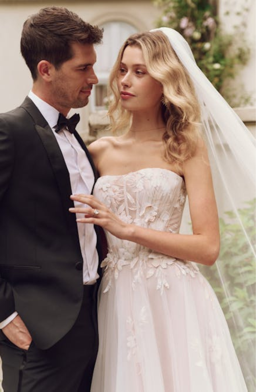 model is wearing a strapless wedding dress with a veil